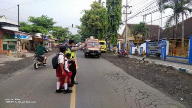Photo of PAM Lantas Poros Pagi Polsek Pasirian Bantu Penyeberangan Anak Sekolah